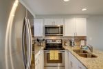 Galley kitchen with stainless steel appliance, granite counters, upgraded cabinets
